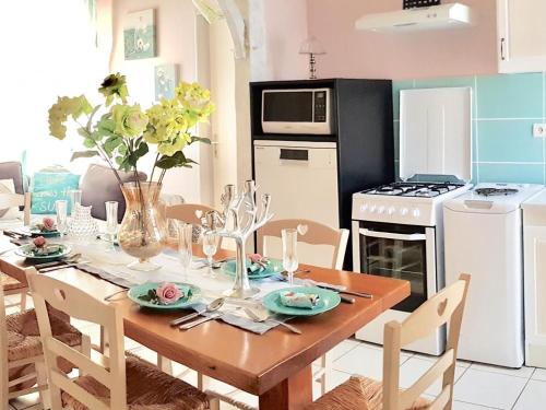 une salle à manger avec une table et une cuisine dans l'établissement Charmante maison rénovée à la ferme, idéale pour familles, à proximité de pêche et nature - FR-1-426-118, à Brem-sur-Mer