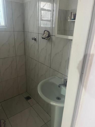 a small bathroom with a sink and a shower at Kitnet Luar in São Thomé das Letras