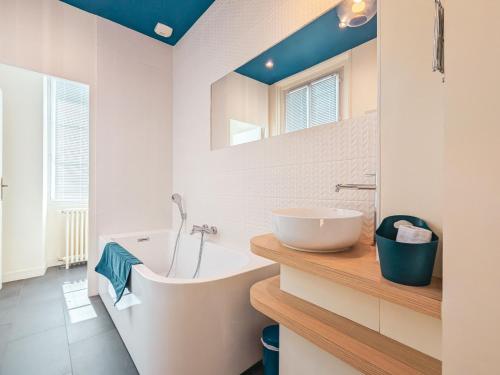 a bathroom with a white tub and a sink at Maison de maître avec jardin, spa et parking au cœur de Châteauroux - FR-1-591-322 in Châteauroux