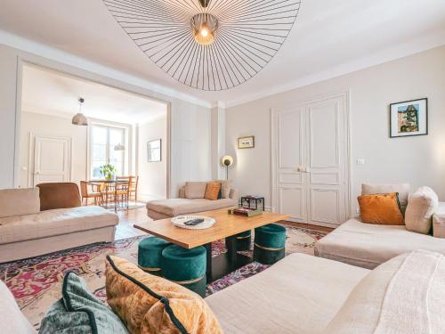 a living room with a couch and a table at Maison de maître avec jardin, spa et parking au cœur de Châteauroux - FR-1-591-322 in Châteauroux