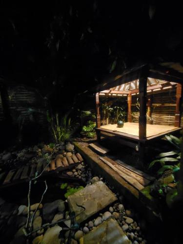 a wooden pavilion in a garden with rocks at Pondok Kebun Jati in Pawenang