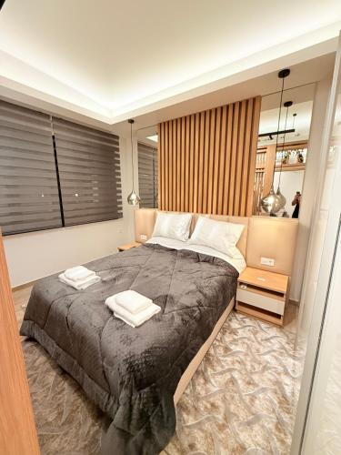 a bedroom with a large bed with two towels on it at Velvet Aura Edessa in Edessa