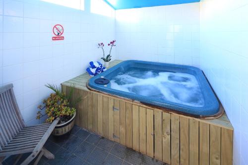 a large blue tub in a room with a bench at Onetangi Beach Apartments in Onetangi