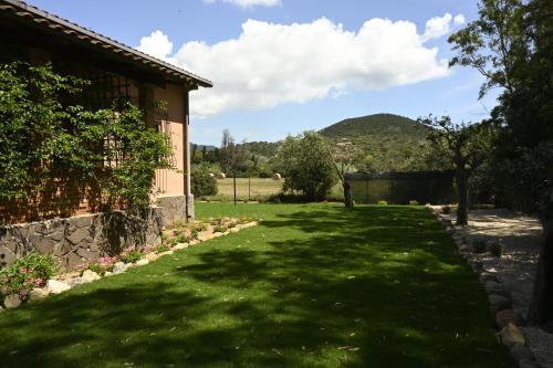 a yard with green grass next to a building at Villa Le Due Spiagge in Chia