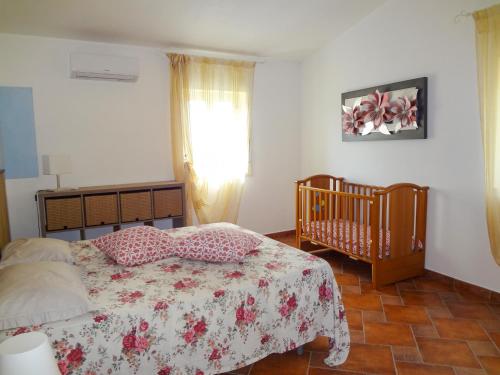 a bedroom with a bed and a crib and a window at Villa il Giglio in Montallegro