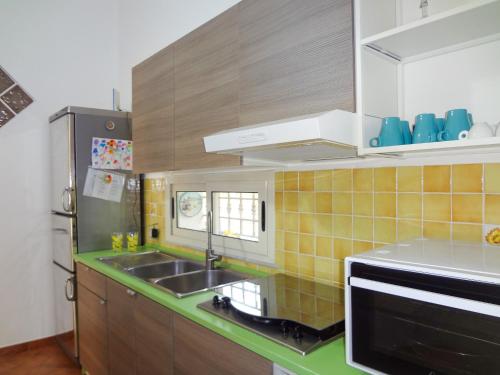 a kitchen with a sink and a microwave at Villa il Giglio in Montallegro