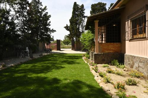 a yard with green grass and a house at Villa Le Due Spiagge in Chia