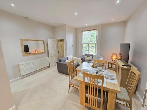 a living room with a table and a couch at Exquisite 2 Bedroom Apartment With Free Parking in Sheffield