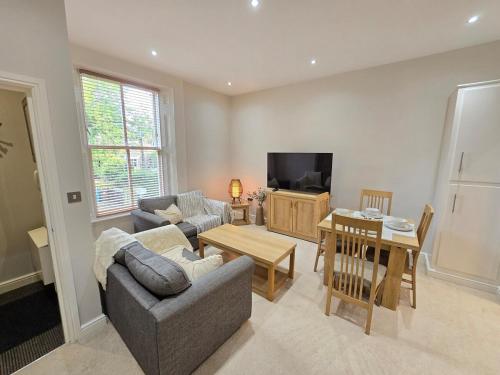 a living room with two couches and a television at Exquisite 2 Bedroom Apartment With Free Parking in Sheffield