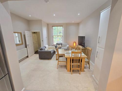 a living room with a table and a couch at Exquisite 2 Bedroom Apartment With Free Parking in Sheffield