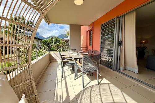 a balcony with a table and chairs on it at Vaiana City Apartment - relaxing downtown Papeete - garden view AC - WiFi in Papeete