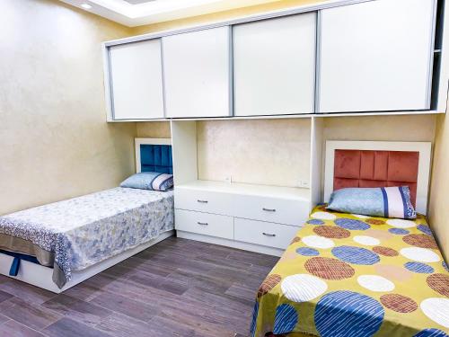 a bedroom with two beds and a large window at Complexe touristique City Center Oued Laou - Pool & Play area in Oued Laou