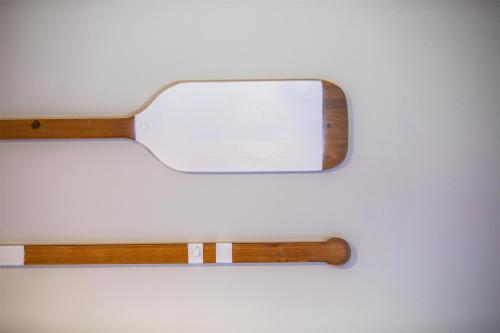 a mirror on a wall with a wooden handle at Nightcap at Ocean Beach Hotel in Umina