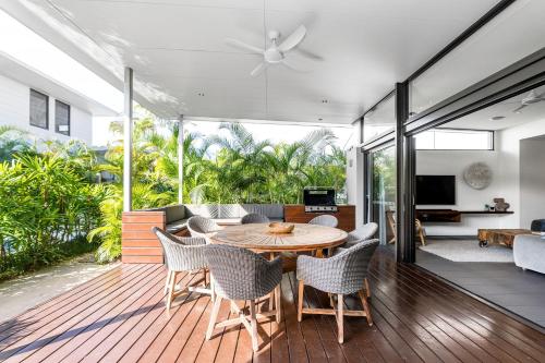 a living room with a wooden table and chairs at Byron Lux Beach Houses in Byron Bay