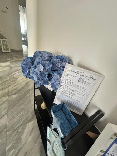a vase filled with blue flowers and a book at Arcola -La Spezia-cinque terre-Lerici in Arcola