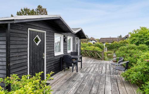 a wooden deck with chairs and a house at 5 Bedroom Awesome Home In Vestervig in Vestervig