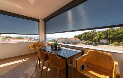 a dining room with a table and chairs and large windows at Nice Apartment In Povljana With Wifi in Povljana