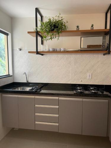 Lindo Apartamento - 600 metros da Praia de Itaparica في فيلا فيلها: مطبخ مع حوض وطاولة عمل