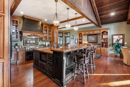 una cocina con armarios de madera y una gran isla con taburetes. en The Lodge at Rock Canyon, en Branson