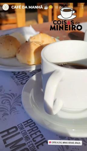 a cup of coffee and a plate of bread at Pousada Bicame de Pedra in Catas Altas