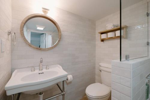 a bathroom with a sink and a toilet and a mirror at The Little Ray - 2 blocks to Beach - Backyard - Walk to Boardwalk in Carolina Beach