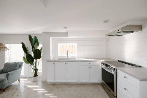 a white kitchen with a sink and a stove at Late Summer Specials - 2 blocks to Beach - Backyard - Walk to Boardwalk in Carolina Beach