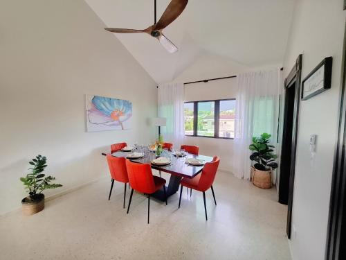 Un comedor con una mesa y sillas rojas. en Paramount Views, en San Felipe de Puerto Plata