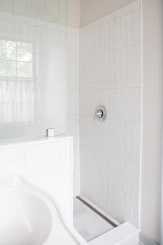 a white bathroom with a shower and a sink at 48" Gas Firepit - Historic DT - Late Summer Specials - Steps to Riverwalk in Wilmington