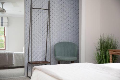 a bedroom with a green chair next to a wall at 48" Gas Firepit - Historic DT - Late Summer Specials - Steps to Riverwalk in Wilmington