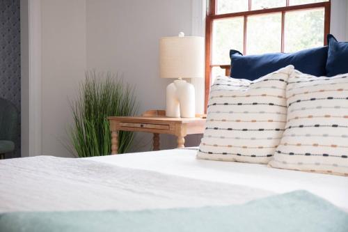 a bed with pillows and a lamp on a table at 48" Gas Firepit - Historic DT - Late Summer Specials - Steps to Riverwalk in Wilmington