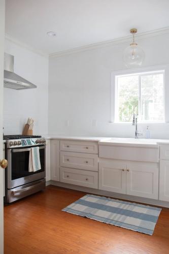 a white kitchen with a sink and a stove at 48" Gas Firepit - Historic DT - Late Summer Specials - Steps to Riverwalk in Wilmington