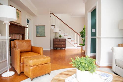a living room with a chair and stairs at 48" Gas Firepit - Historic DT - Late Summer Specials - Steps to Riverwalk in Wilmington
