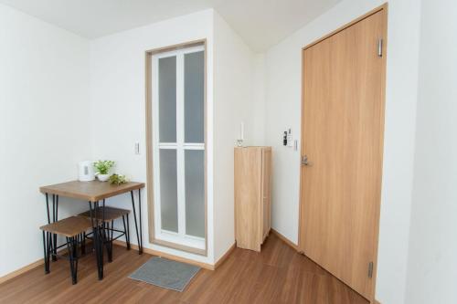 a small room with a table and a door at Natsuumi ホテル 302高级独栋别墅 独立卫浴 地铁站步行五分钟 成田机场-羽田机场-上野直达 in Tokyo