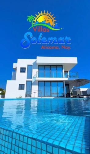 a building with a swimming pool in front of it at Villas Solemar, Aticama in Aticama