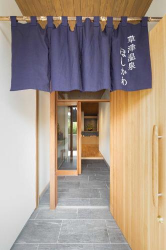 a blue curtain is hanging over a hallway at Kusatsuonsen Hoshikawa in Kusatsu