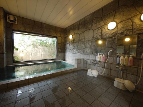 a bathroom with a swimming pool and a window at Hotel Route-Inn Nakano in Nakano