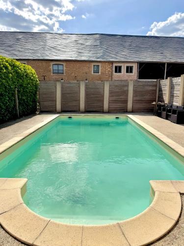une piscine devant une maison dans l'établissement Hôtel de l Héritage, à Crannes-en-Champagne