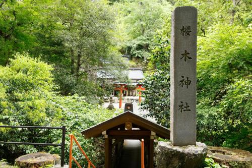 a small shrine with writing on it in a garden at 吉野宮滝 サウナ付き-2025年9月1日以降-古民家 ちょうちんの宿 in Yoshino
