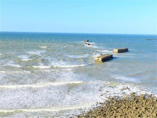 a body of water with waves and a beach at City View Family Retreat in Isigny-sur-Mer