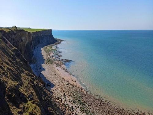an aerial view of the ocean and a rocky beach at City View Family Retreat in Isigny-sur-Mer