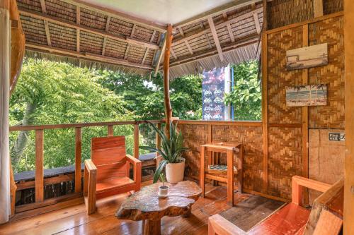 a room with a table and chairs on a porch at Soffta Surf Ranch in General Luna