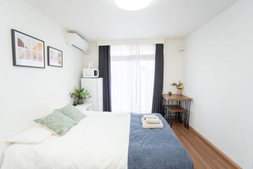 a bedroom with a white bed with a blue rug at 夏美ホテル 303高级独栋别墅 独立卫浴 地铁站步行五分钟成田机场-羽田机场-上野-晴空塔一线直通 in Tokyo
