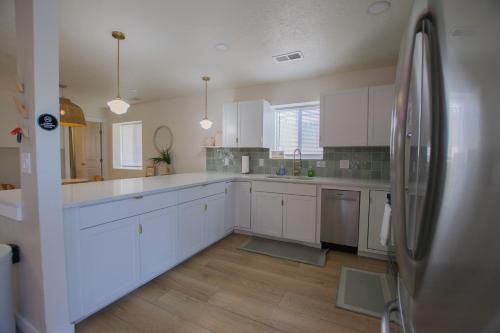 eine Küche mit weißen Schränken und einem Edelstahlkühlschrank in der Unterkunft Bohemian Chic an Eclectic Escape-Hot Tub-Pet Friendly-No Pet Fees! in Albuquerque