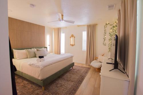 ein Schlafzimmer mit einem Bett und einem Flachbildfernseher in der Unterkunft Bohemian Chic an Eclectic Escape-Hot Tub-Pet Friendly-No Pet Fees! in Albuquerque
