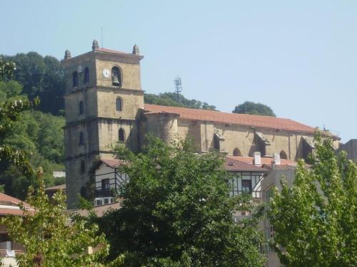 a building with a tower with a clock on it at Pension & resataurante AMAZKAR in Oiartzun