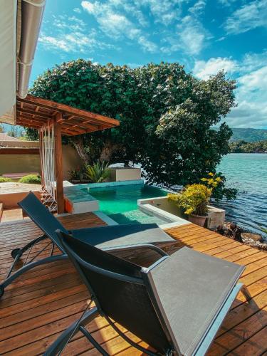 a deck with a chair and a swimming pool at Villa Mitirapa in Tohautu