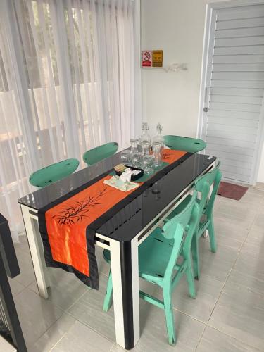 a black table with green chairs around it at Asaan Homestay in Ciburial