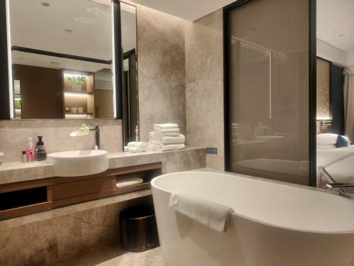 a bathroom with a tub and a sink and a mirror at Beijing Guangxi Hotel in Beijing