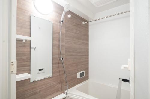 a shower with a glass door in a bathroom at URBANEX Komagome in Tokyo