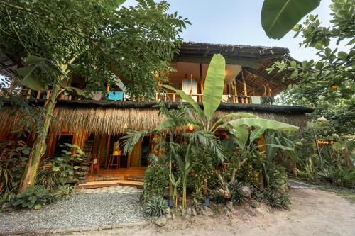 a house with a lot of plants in front of it at Soffta Surf Ranch in General Luna